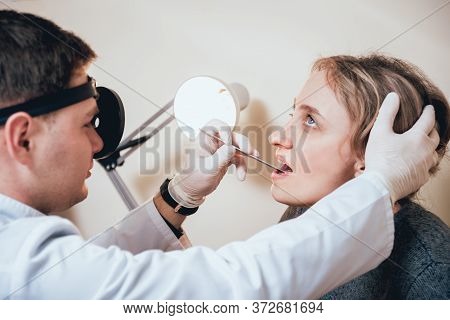 Otolaryngologist Examines Womans Throat With Medical Spatula.