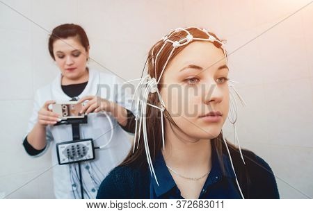 Doctor And Patient With Encephalography Electrode. Electroencephalogram