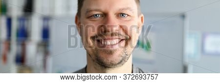 Unshaven Man In T-shirt Stands At Home And Smiles. Sit At Home And Relax. Take Breath Before New Wor