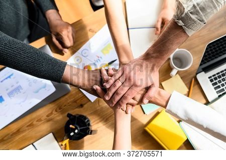 A Multiracial Team, Coworkers Put Their Hand On Hand Of One Another. A Sign Of A Close-knit Multical