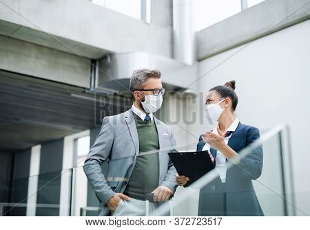 Flight Attendant Talking To Businessman On Airport, Wearing Face Masks.