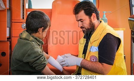 Aleppo, Syria 12 April 2020
A Nurse Embraces A Child And Treating Him Inside The Ambulance
