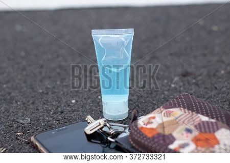 A Blue Alcohol Gel Bottle Placed On A Gray Background Placed With Everyday Equipment Such As Mobile