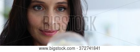 Close-up Of Focused Woman Looking Attentively At Silicone Implants With Interest. Smiling Lady Think