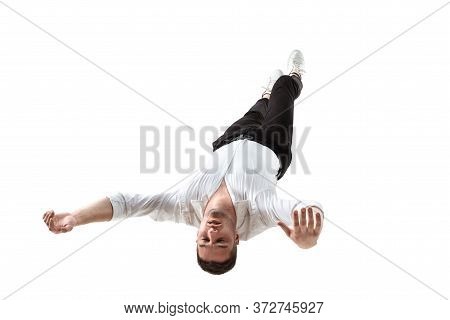 Mid-air Beauty Cought In Moment. Full Length Shot Of Young Man Hovering In Air And Keeping Eyes Clos
