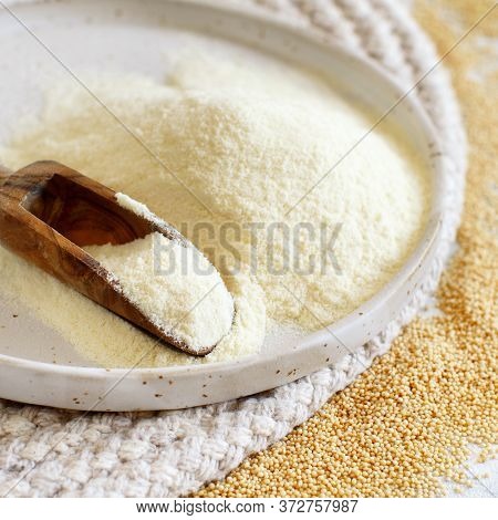 Plate Of Raw Amaranth Flour With A Spoon And Amaranth Seeds Close Up