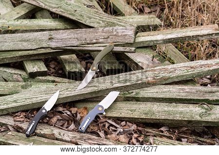 Three Knives Lie On Wooden Boards. Photo Of Knives On The Nature.