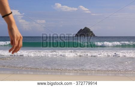 Hand Of Woman And Wave Background At Mawun Beach. Kuta Lombok Is An Exotic Paradise On The Indonesia