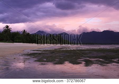Beautiful Purple Sunset Colors Pantai Sejuk Pundewa Beach. Exotic Tropical Destination Beach On Isla
