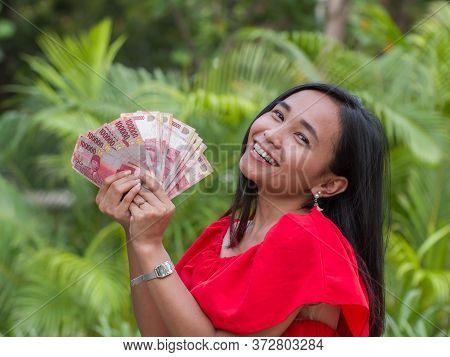 Indonesian Money In The Hands Of An Asian Girl.