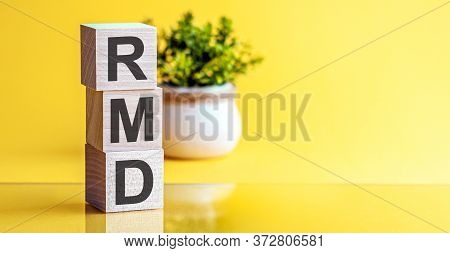 Wooden Block With Words Rmd Required Minimum Distributions. Bright Yellow Background.