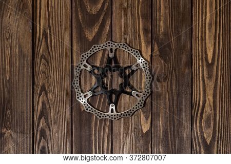 Bicycle Brake Disc On A Wooden Table. Bicycle Repair Shop. Bike Parts Store.