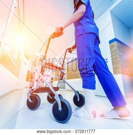 Patient On Rollator With Hand Brakes Moving In Hospital