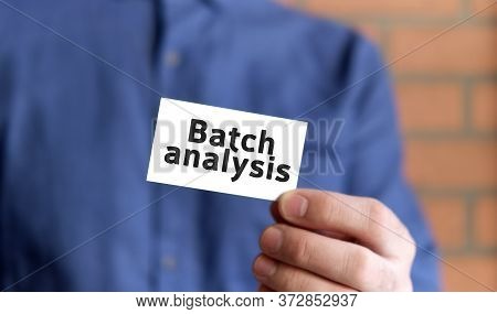 A Man In A Blue Shirt Holds A Sign With The Text Of Batch Analysis In One Hand