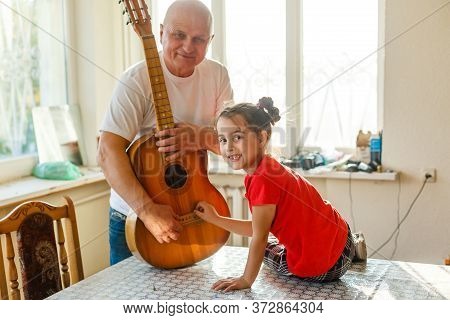 Closeup Mans Hand Changing Strings On His Old Acoustic Guitar.