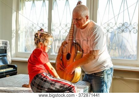 Closeup Mans Hand Changing Strings On His Old Acoustic Guitar.