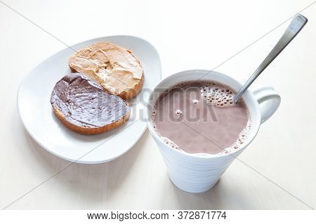 Above View Of Cup With Cocoa And Toasts With Peanut Butter And Chocolatte And Hazelnut Spread On Pla