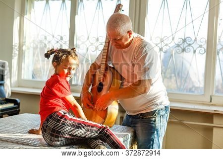 Closeup Mans Hand Changing Strings On His Old Acoustic Guitar.