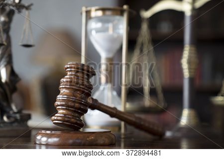 Law Theme. Judge Chamber. Gavel And Themis Statue On Brown Shining Desk. Collection Of Legal Books I
