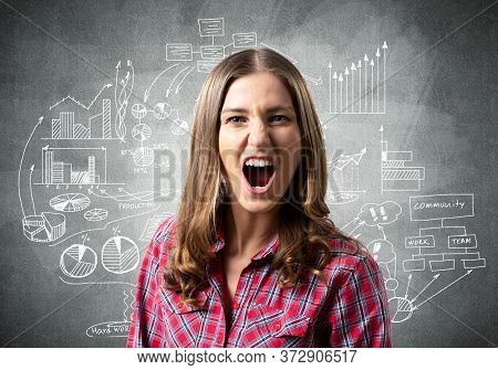 Frenzied Young Woman Screaming With Anger. Financial Charts And Business Doodles On Grey Wall. Emoti