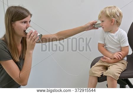 A Boy With Cochlear Implants Playing Tin Can Phone