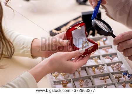Young woman visiting old male jeweler