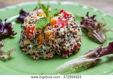 Closeup On Green Plate With Tri-color Quinoa Salad On Wooden Table - Quinoa Is A Pseudograin That Ha