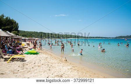 Chalkidiki, Greece, July 25 2017: People Swimming And Enjoying Summer Vacations. Paliouri Beach, Kha