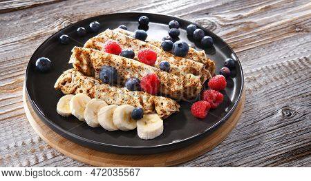 A Plate Of Pancakes With Cheese And Fruits