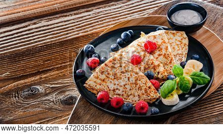 A Plate Of Pancakes With Cheese And Fruits
