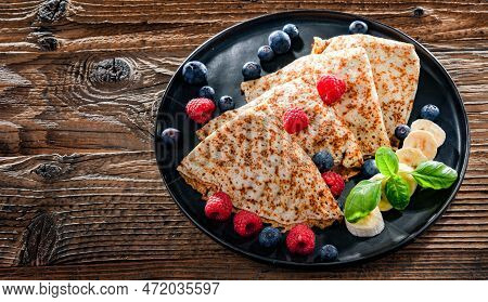 A Plate Of Pancakes With Cheese And Fruits