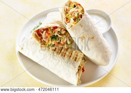 Tortilla Wraps With Chicken And Fresh Vegetables On Plate Over Light Background. Close Up View
