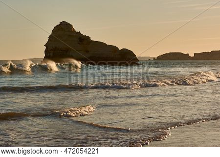 Big Limestone Rock Washed By Ocean Waves At Sunset. Praia Dos Três Castelos In Portimão, Portugal