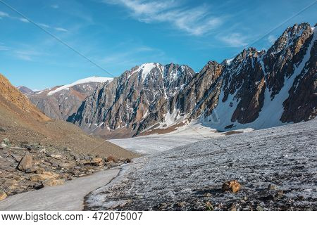Scenic Mountain Landscape With Glacier Under Sharp Rocks In Sunlight. Awesome Landscape With Glacial