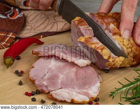 A Piece Of Juicy And Tasty Bacon Is Cut With A Kitchen Knife Into Appetizing Pieces. Close-up Of Fem