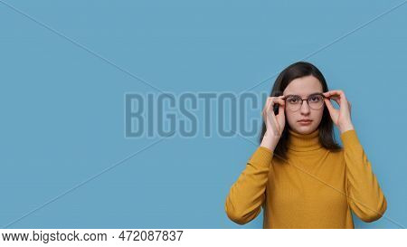 A Smiling Teenage Student Girl Taking Off Or Putting On Glasses On A Blue Background. Girl Sees Bett