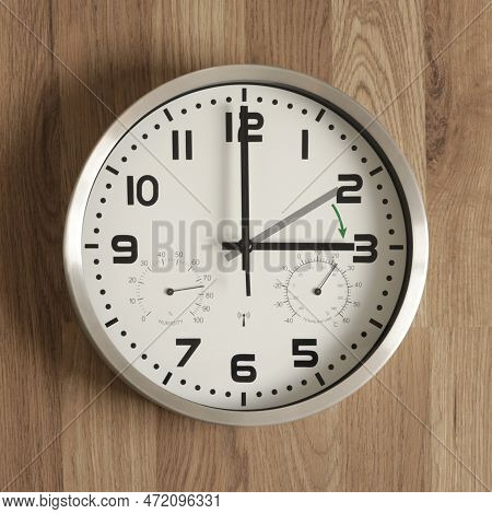 A Watch, The Gray Hand Points To Two O'clock, The Black One To Three O'clock. The Green Arrow Indica