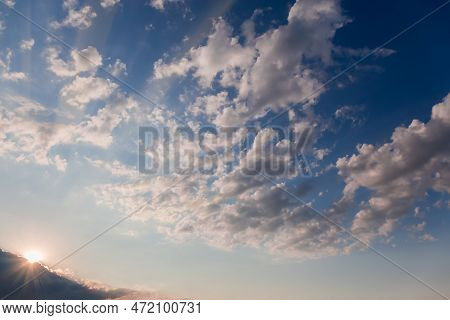 Section Of Blue Sky With Altocumulus Clouds And Sun Beams From Behind The Storm Cloud In Summer