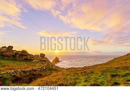 Sunset View Of The Lands End Coastline Landscape, With The Longships Lighthouse, In Cornwall, Englan