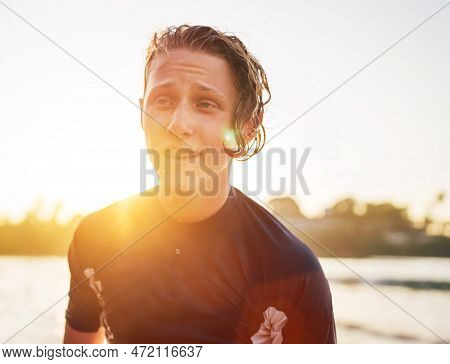 Portrait Of A Handsome Teen Boy Surfing Rashguard On The Sand Indian Ocean Beach With Sunset On Back