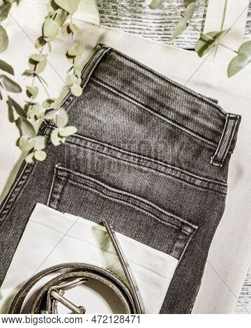 Wardrobe Idea. Sustainable Still Life With Jeans, T-shirt, Belt On Textile Bag On Wooden Background 