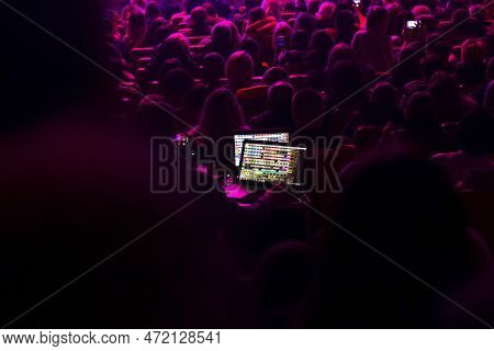 Auditorium Seat In The Theather. Soundman On The Mixing Console During A Concert. Soundman Working O