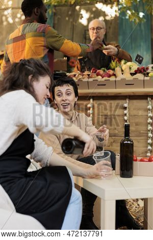 Friendly Vendor Pouring Organic Biodynamic Wine To Female Customer While Selling Her Local Natural P