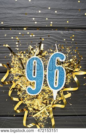 Number 96 Blue Celebration Candle And Gold Confetti On Dark Wooden Background. 96th Birthday Card. A