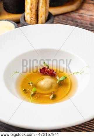 Ravioli Consomme On A White Porcelain Plate. Healthy Eating Concept