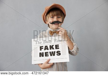 Newsboy Shouting Against Grunge Wall Background. Boy Selling Fake News