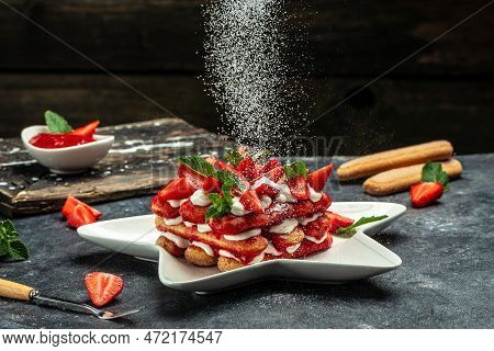 Italian Dessert Tiramisu Cake With Fresh Strawberry, Biscuit And Whipped Cream And Mint On A Dark Ba