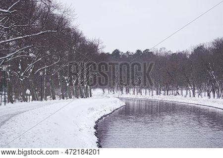 Scenic View Of Canal Admist Snow Covered Land Against Clear Sky