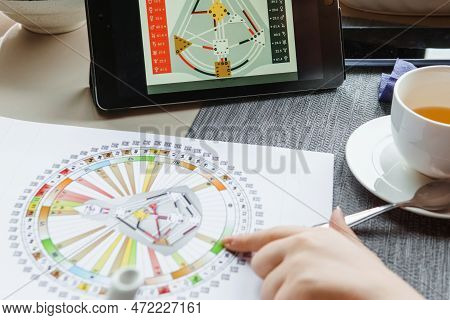 Tver, Russia - February 12, 2023: A Woman At The Table Is Studying A Rave Mandala By Human Design. R