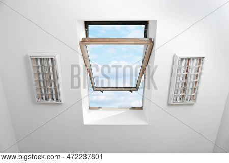 Open Skylight Roof Window On Slanted Ceiling In Attic Room, Bottom View